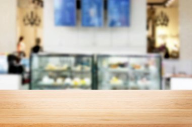 Seçilen odak boş kahverengi ahşap masa ve kahve dükkanı veya restaurent bokeh görüntü ile arka plan bulanıklık. Fotomontaj veya ürün ekran.