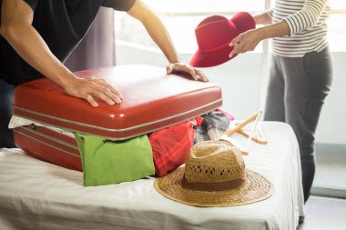 adam onun kırmızı bavul tatil önce paketleme için tüm giyim girmeye çalışıyoruz