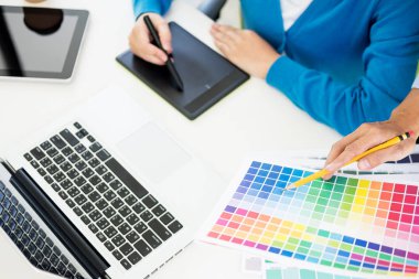 Yaratıcı veya pantone renk örneği ve planları ofis masası üzerinde bina ile iç tasarımcılar ekip çalışması mimarlar tasarım projesi bir masaüstü bilgisayar ve bazı renk örneklerini kullanarak seçim seçerek renk örnekleri