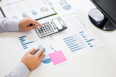 Ofiste çalışan işadamı bilgisayarında, tabletinde ve çalışma masasında veri dokümanlarıyla çalışıyor..