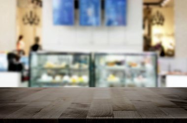 Seçilen odak boş kahverengi ahşap masa ve kahve dükkanı veya restaurent bokeh görüntü ile arka plan bulanıklık. Fotomontaj veya ürün ekran.