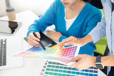 Yaratıcı veya pantone renk örneği ve planları ofis masası üzerinde bina ile iç tasarımcılar ekip çalışması mimarlar tasarım projesi bir masaüstü bilgisayar ve bazı renk örneklerini kullanarak seçim seçerek renk örnekleri