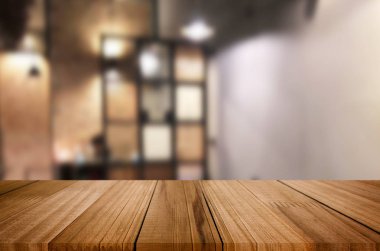 Seçilen odak boş kahverengi ahşap masa ve kahve dükkanı veya restaurent bokeh görüntü ile arka plan bulanıklık. Fotomontaj veya ürün ekran.