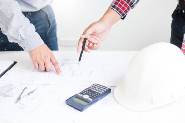 Yakın çekim, kişinin mühendis el çizim planı üzerinde mavi baskı mimar ekipmanlı, mimarlar tablo, takım çalışması ve iş akışı inşaat kavramı tartışmaya.