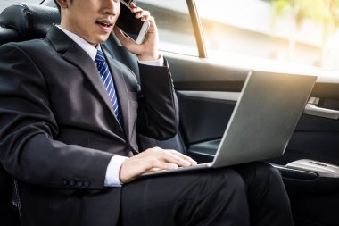 Çekici genç iş adamı. Arabada cep telefonu kullanıyor..