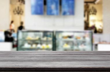 Seçilen odak boş kahverengi ahşap masa ve kahve dükkanı veya restaurent bokeh görüntü ile arka plan bulanıklık. Fotomontaj veya ürün ekran.