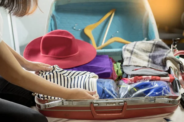 Woman hand packing a luggage for a new journey and travel for a long weekend