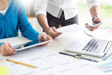 Yaratıcı veya pantone renk örneği ve planları ofis masası üzerinde bina ile iç tasarımcılar ekip çalışması mimarlar tasarım projesi bir masaüstü bilgisayar ve bazı renk örneklerini kullanarak seçim seçerek renk örnekleri