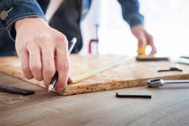 Marangoz, marangozluk planları eser dikkatle bakarak çalışma. Onun işyerinde başarılı bir girişimci olduğunu. Destekler üzerinde inşaat alanında iş kesici ile çivi çekiç