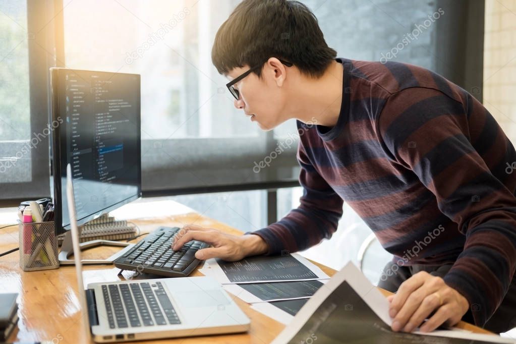 Pensive programmer working on on desktop pc programming code technologies or website design at office Software Development Company. 