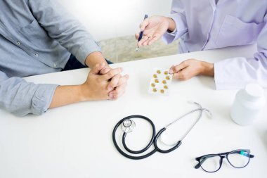 Tablet ilacın tutan el doktor ve hasta hastane odasında açıklamak