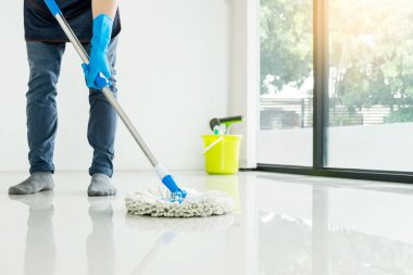 Genç hizmetçi paspas ve plastik kova fırçalar, eldiven ve deterjanlar ile eşi yardımcı bırakarak Oda ev yerde tutarak yere mobbing Temizleme