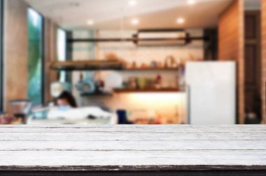 Seçilen odak boş kahverengi ahşap masa ve kahve dükkanı veya restaurent bokeh görüntü ile arka plan bulanıklık. Fotomontaj veya ürün ekran