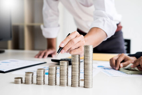 человек, указывающий цели написания на бумаге, составление бизнес-плана на рабочем месте, человек с ручками, бумагами, записками в документах, экономия денег концепция, график, стопки монет, диаграмма и ручка
