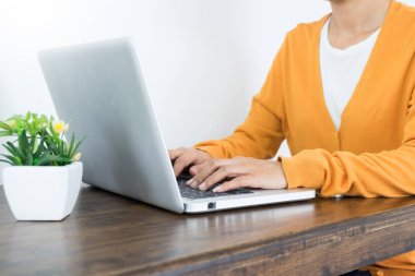 Çekici genç güzel girişimci kadın gülümseyerek ve dizüstü bilgisayar ekranına bakarak evden çalışma 