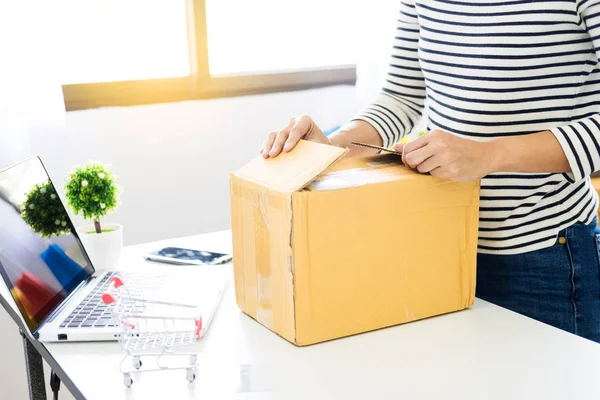 e-commerce delivery concept and online selling start up small business owner packing in the card box at workplace. freelance woman seller prepare product for packaging process at shop.