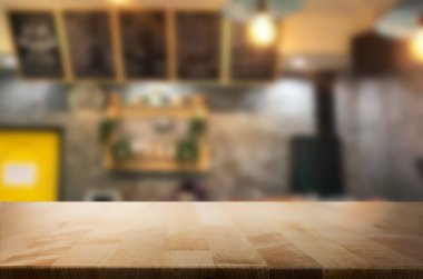 Seçilen odak boş kahverengi ahşap masa ve kahve dükkanı veya restaurent bokeh görüntü ile arka plan bulanıklık. Fotomontaj veya ürün ekran