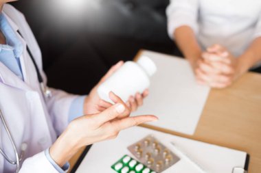 Tablet ilacın tutan el doktor ve hasta hastane odasında açıklamak.