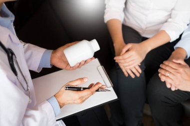 Tablet ilacın tutan el doktor ve hasta hastane odasında açıklamak.