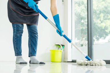 Genç hizmetçi paspas ve plastik kova fırçalar, eldiven ve deterjanlar ile eşi yardımcı bırakarak Oda ev yerde tutarak yere mobbing Temizleme
