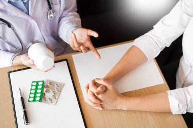 Tablet ilacın tutan el doktor ve hasta hastane odasında açıklamak.