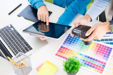 Yaratıcı veya pantone renk örneği ve planları ofis masası üzerinde bina ile iç tasarımcılar ekip çalışması mimarlar tasarım projesi bir masaüstü bilgisayar ve bazı renk örneklerini kullanarak seçim seçerek renk örnekleri