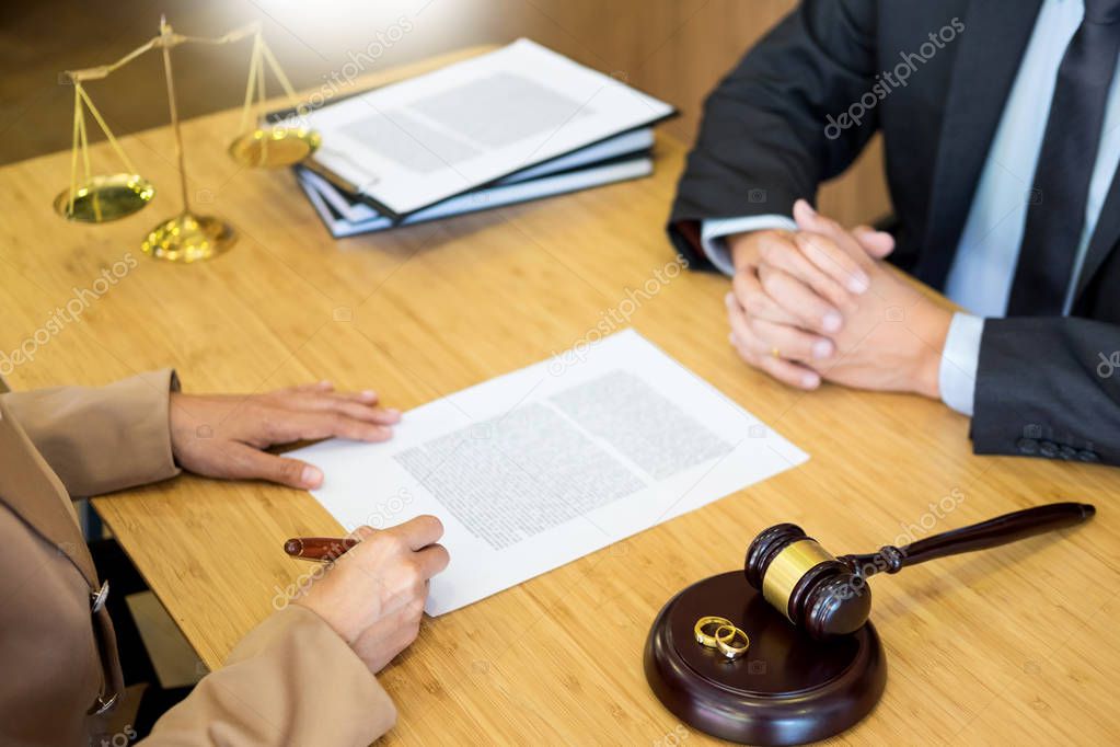 couple problems sitting a marriage Golden wedding rings judge gavel deciding on marriage divorce signing divorce documents or premarital agreement provide legal advice of lawyer and consoling to his clients