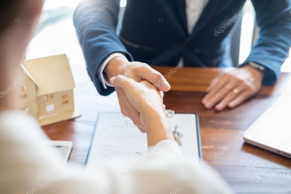 House developers agent or financial advisor and customers shaking hands after signing document making deal as successful agreement, contract with a firm