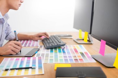 grafik tablet ve renk paletinde bilgisayar stüdyo veya office ile masa başında oturan yeni bir proje Tasarımcısı Editör çizim işyerinde skeçler.