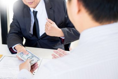 İşadamı ya da rüşvet ve para ile el sallayarak takım elbiseli, yolsuzluk ticaret Döviz kavramı alarak politikacı