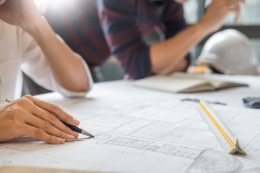 profesyonel mimarlar tartışırken inşaat planları, inşaat mühendisi, iş ekip çalışması kavramı ortak çalışma planı üzerinde çalışma