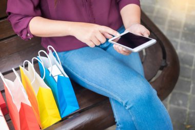 Bir gün alışveriş tadını çıkarırken cep telefonu ile alışveriş merkezinde paperbags bak kadın