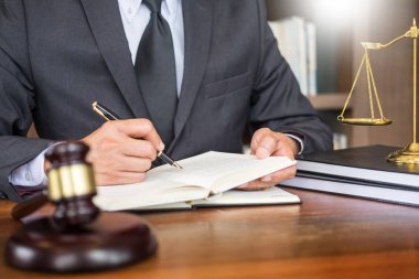 Danışman bir genç avukat mevzuat tokmak ve ahşap masa üzerinde belge ile özel Ofis İşyeri