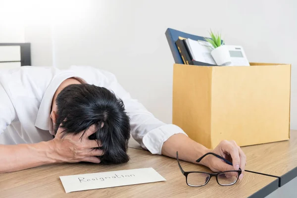 Businessmen are holding resignation document and packing personal company on brown cardboard box changing work, unemployment or resign concept.