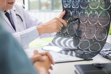 Doktor bir tarama veya röntgen film analiz veya bir anomali beyin hasta tedavi konuşurken bir Ct taraması düşünceli ifadeler yöntemi açıklar 