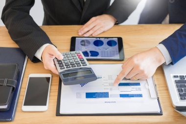 Yeni bir mali plan başlangıç projesi ile hesap makinesi ile tartışırken takım iş çalışma. kar grafiği planı analiz hesaplama ofiste.