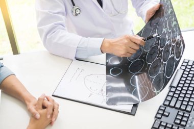 Doktor bir tarama veya röntgen film analiz veya bir anomali beyin hasta tedavi konuşurken bir Ct taraması düşünceli ifadeler yöntemi açıklar 