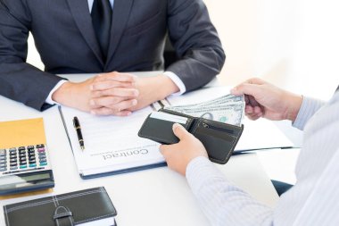 İşadamı ya da rüşvet ve para ile el sallayarak takım elbiseli, yolsuzluk ticaret Döviz kavramı alarak politikacı