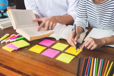 Genç öğrenciler sınıf çalışma kitabı yakalamak ve bir Kütüphane, eğitim ve okul kavramı özel ders öğrenme arkadaş yardım.