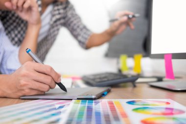 tasarımcı grafik yaratıcı yaratıcılık birlikte meslektaşı ile masada grafik tablet ve kalem kullanarak boyama çalışma 