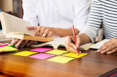 Genç öğrenciler sınıf çalışma kitabı yakalamak ve bir Kütüphane, eğitim ve okul kavramı özel ders öğrenme arkadaş yardım.