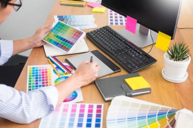 grafik tablet ve renk paletinde bilgisayar stüdyo veya office ile masa başında oturan yeni bir proje Tasarımcısı Editör çizim işyerinde skeçler