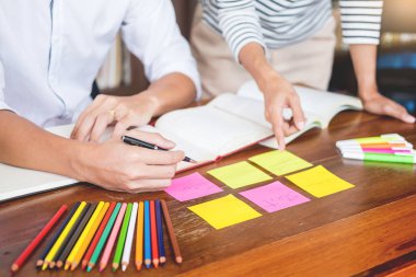 Genç öğrenciler sınıf çalışma kitabı yakalamak ve bir Kütüphane, eğitim ve okul kavramı özel ders öğrenme arkadaş yardım.