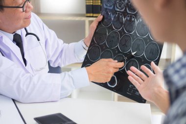Doktor bir tarama veya röntgen film analiz veya bir anomali beyin hasta tedavi konuşurken bir Ct taraması düşünceli ifadeler yöntemi açıklar 