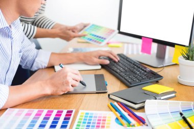 tasarımcı grafik yaratıcı yaratıcılık birlikte meslektaşı ile masada grafik tablet ve kalem kullanarak boyama çalışma 