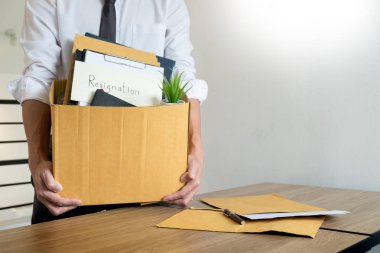 İş adamları istifa belge tutarak ve kişisel şirket üzerinde kahverengi karton ambalaj kutusu değişen iş, işsizlik veya kavramı istifa.