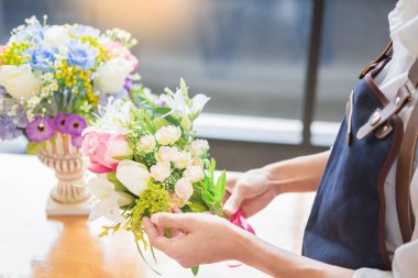 Güzel yapay buket çiçek mağazası, iş, satış ve floristik el sanatları ve el yelek yapmak düzenleme kullanarak iş yerinde kadın çiçekçi kavramı yapılan