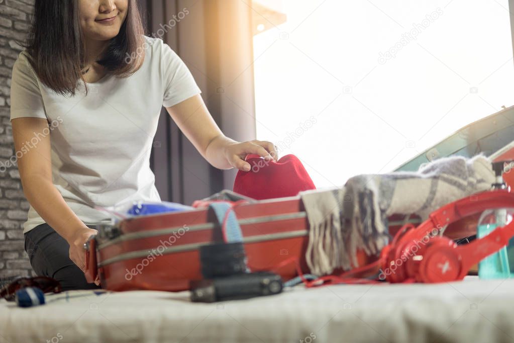 Woman hand packing a luggage for a new journey and travel for a long weekend 