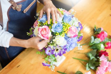 Güzel yapay buket çiçek mağazası, iş, satış ve floristik el sanatları ve el yelek yapmak düzenleme kullanarak iş yerinde kadın çiçekçi kavramı yapılan