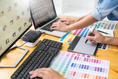 Tablet ve kalem, içinde meşgul yaratıcı bürolar kullanarak resmi düzenleme renk örneklerini kullanarak web tasarım grafik tasarımcı ekibi